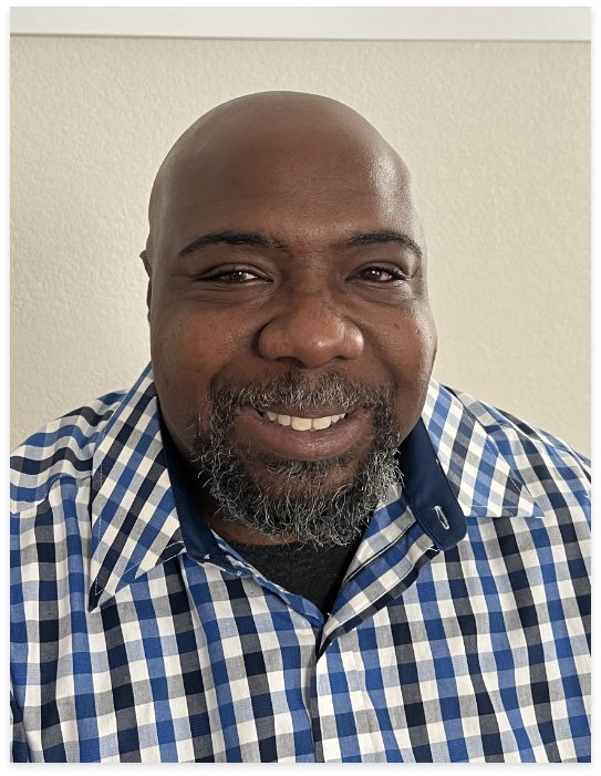Rafael, co-founder of Ourconic, smiling in a blue and white checkered shirt